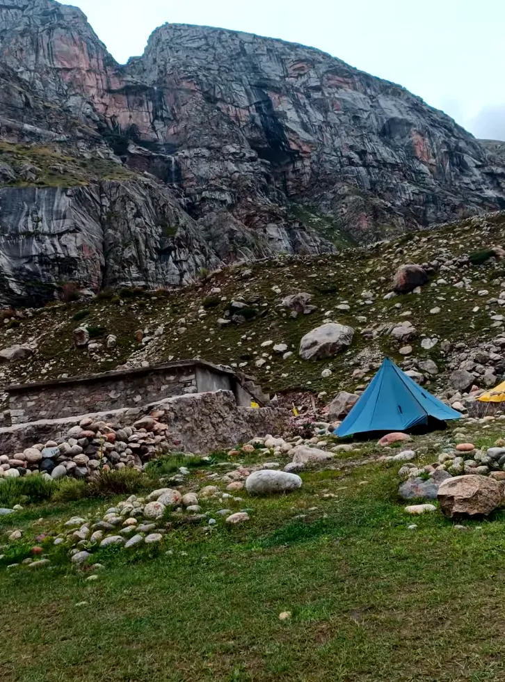 Chatru campsite on Hampta Pass Trek with alpine tents, rocky mountain terrain, and scenic Himalayan valley landscape
