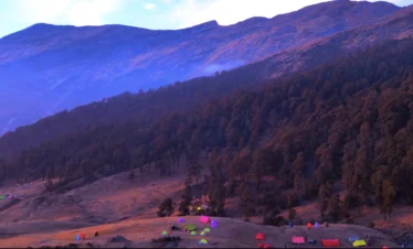 Brahmatal Trek campsite with Himalayan forest, colorful tents during Brahmatal winter trek, scenic mountain campsite Uttarakhand, Himalayan trekking camp India, best camping trek in Uttarakhand
