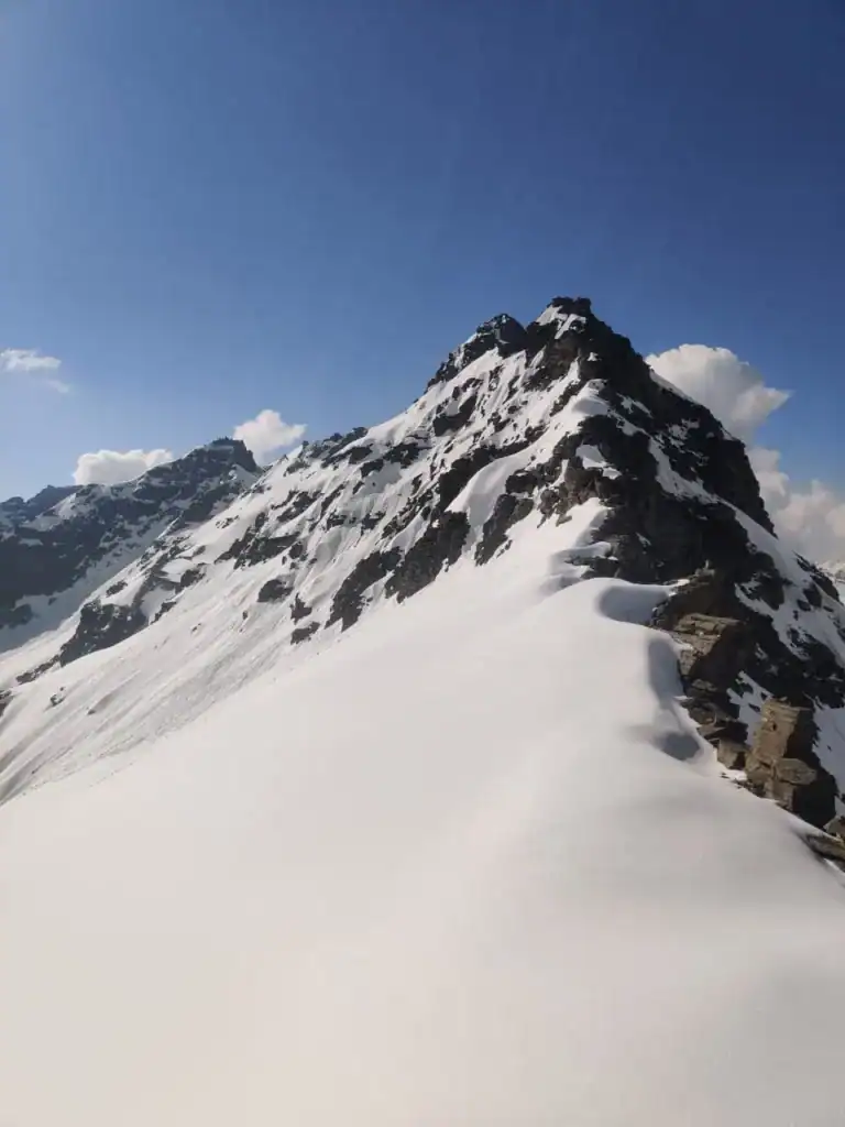 Snow-covered mountain peak during a clear day in the Himalayas.